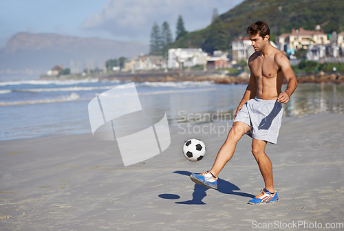 Image of Man, beach and playing with soccer ball for game, sports or exercise in outdoor hobby, training or practice. Young male person or football player on ocean coast for match or cardio workout by seaside