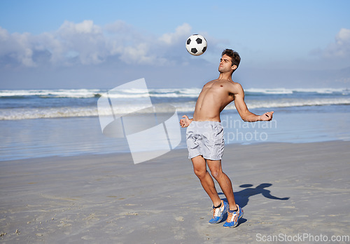 Image of Man, beach and playing with soccer ball for game, sports or exercise in outdoor hobby, training or practice. Young muscular male person or football player in match or cardio workout by ocean coast