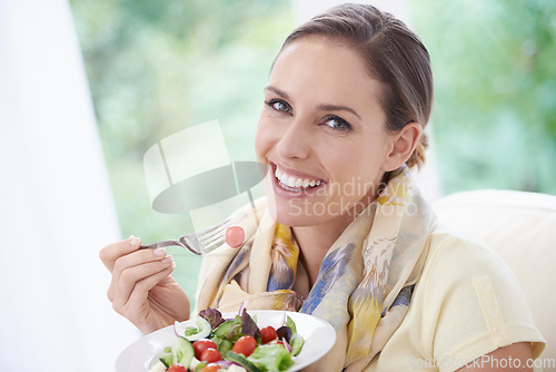 Image of Woman, smile and eating salad in home for diet, health and wellness with pride at lunch in lounge. Person, food and hungry with vegetables, plate and nutrition with vitamins, fiber and relax in house