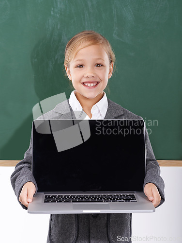 Image of Child, girl and laptop screen in classroom for education, online school and marketing space against a chalkboard. Happy student or kid in portrait with computer mockup for e learning presentation