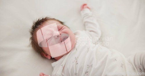 Image of Newborn, face and sleeping with dream on bed in nursery for relaxing or resting with child development. Baby, tired and waking up in bedroom of house with calm, relax and cute infant in family home