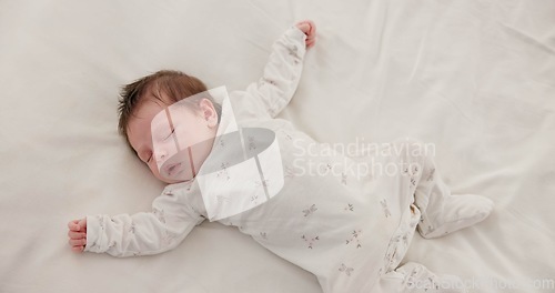 Image of Sweet, sleeping and newborn baby on a bed at a home in the bedroom for resting and dreaming. Cute, tired and top view of infant, child or kid taking a nap in the morning in nursery at family house.