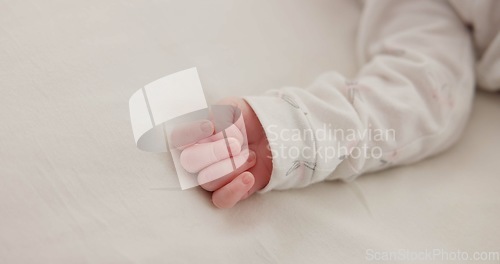 Image of Hand, baby and sleeping on bed in nursery for child development, childcare and nurture in home. Newborn, resting or relaxing in bedroom with rest, dreaming or closeup for wellness and health in house