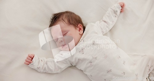 Image of Cute, sleeping and newborn baby on a bed at a home in the bedroom for resting and dreaming. Tired, sweet and top view of infant, child or kid taking a nap in the morning in nursery at family house.