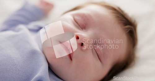 Image of Face, growth and sleep with a baby on a bed closeup in a home, dreaming during a nap for child development. Relax, calm and rest with an adorable newborn infant asleep in a bedroom for comfort