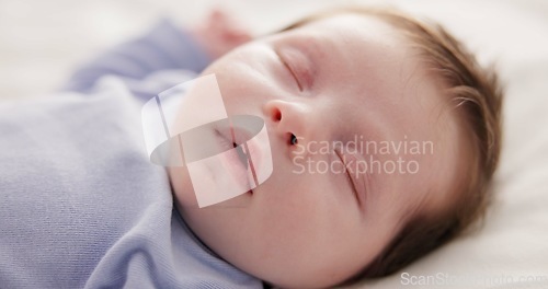 Image of Face, relax and sleep with a baby on a bed closeup in a home, dreaming during a nap for child development. Growth, calm and rest with an adorable newborn infant asleep in a bedroom for comfort