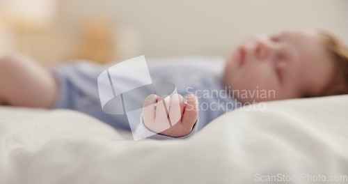 Image of Hand, baby and sleeping on bed in nursery with relaxing, resting and nap on blanket in morning. Newborn, peaceful and dreaming in bedroom of home for child development, growth and nurture or relax