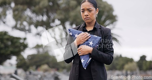 Image of Funeral, death and american flag with a woman in a graveyard for mourning during a memorial service. Sad, usa and an army wife as a lonely widow at a cemetery feeling the pain of loss or grief