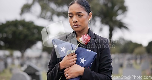 Image of Funeral, death and rose for a woman with a flag at a cemetery in mourning at a memorial service. Sad, usa and an army wife as a widow with a flower in a graveyard feeling the pain of loss or grief