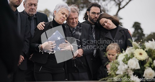 Image of Funeral, cemetery and family with American flag for soldier for respect, ceremony and memorial service. Sad, depression and people by coffin in graveyard mourning military, army and veteran hero