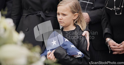 Image of Funeral, cemetery and child with American flag for veteran for respect, ceremony and memorial service. Family, depression and sad girl by coffin in graveyard mourning military, army and soldier hero