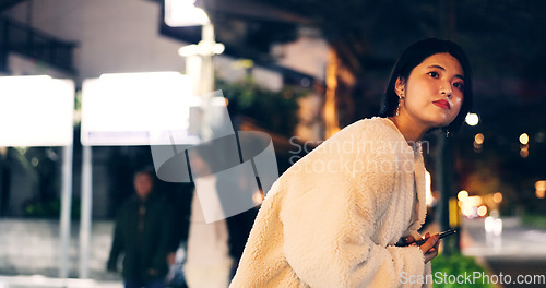 Image of Japanese woman, taxi and smartphone at night for location, city street and looking for transport. Person, waiting and cab search with cellphone app for travel, road and tokyo town with technology