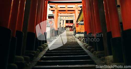 Image of Stairs in Torii gate tunnel with temple, peace and mindfulness on travel with spiritual history. Architecture, Japanese culture and steps on orange path at Shinto shrine monument in forest in Kyoto