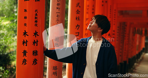 Image of Thinking, walking and man in Torii gate in Kyoto with peace, mindfulness and travel with spiritual history. Architecture, Japanese culture and person in orange tunnel at Shinto shrine in zen mindset.