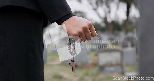 Image of Rosary, death or hand cemetery for funeral. spiritual service or grave visit to repsect the Christian religion. Mourning, goodbye or closeup of person outside in graveyard for grief, loss or farewell