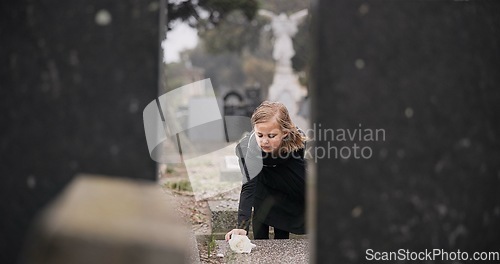 Image of Flower, death or kid in cemetery for funeral. spiritual service or tombstone for respect in Christian religion. Mourning, sad or depressed girl child outside in graveyard for grief, loss or farewell