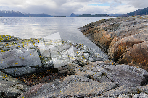 Image of Tranquil view of the sea with rocky coastline and distant mounta