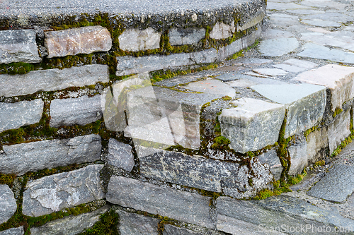Image of Moss-covered stone steps in an outdoor setting during daytime