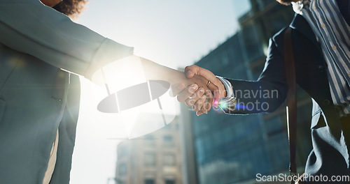 Image of Outdoor, business people and professional with handshake, conversation and contract with lens flare, corporate and talk. Staff, employees in a city and coworkers with hello, partnership or urban town