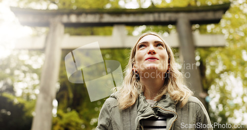 Image of Woman, forest and torii gate in Kyoto with peace, mindfulness and travel with spiritual history. Architecture, japanese culture and shinto shrine in woods with sculpture, memorial and monument