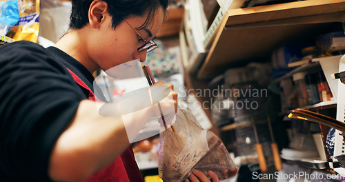 Image of Japanese chef man, chopsticks and kitchen with plastic, search bag and thinking with stirring for cooking. Person, restaurant worker or catering service with cuisine, meal prep and nutrition in Tokyo