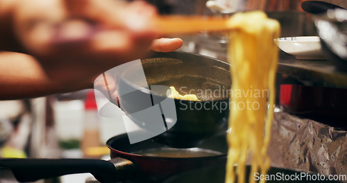 Image of Cooking, food market and person with noodles on gas stove for meal preparation, eating and restaurant. Japanese culinary, flame and closeup of chopsticks to prepare lunch, cuisine dinner and supper