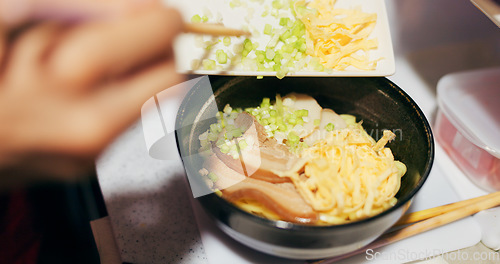 Image of Japanese, ramen and food in restaurant with spring onion and ingredients, chopsticks and chef skill with decoration. Person cooking traditional cuisine, closeup with nutrition and garnish on noodles