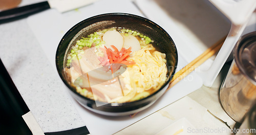 Image of Ramen food, plate and table in restaurant with person, hands and ginger with closeup for Japanese cuisine. Niboshi bowl, chopsticks and pork for diet, nutrition and catering for wellness in Tokyo