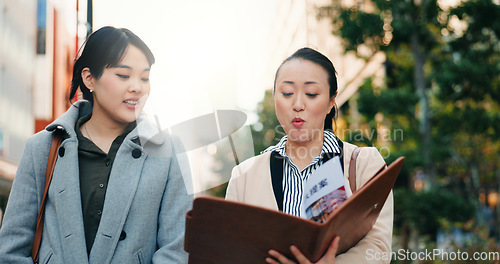 Image of Talking, walking and Japanese women with a document in the city for business or teamwork on a project. Morning, smile and hr manager in Japan reading a report with an employee for recruitment