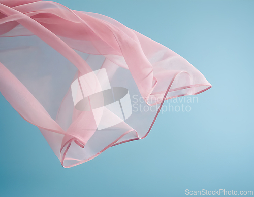 Image of Flying pink fabric wave on blue background, flowing waving silk 