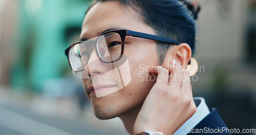 Image of Business man, city and listening to music, digital podcast and streaming audio connection with earphones. Face, Japanese employee and thinking of sound for radio subscription in urban street in Tokyo