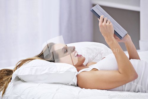 Image of Excited woman, bedroom and tablet for online streaming, reading news or watch funny video on social media. Young person relax on bed with wow, happy or laughing on digital technology or web at home