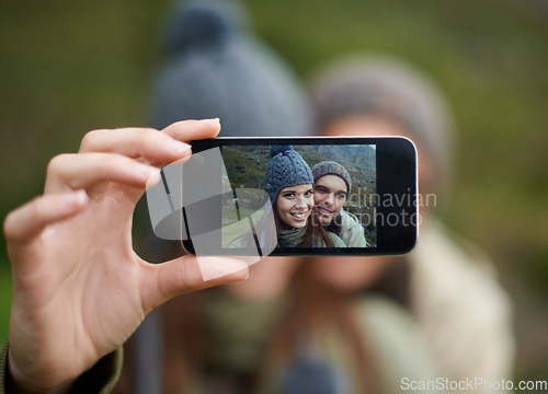 Image of Couple, hiking and smartphone for selfie in nature, camera and capture moment in outdoors. People, happy and picture for memory and exploring wilderness, trekking and photograph for social media