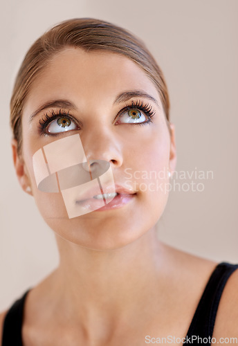 Image of Face, beauty and skincare of woman in makeup for spa facial treatment for aesthetic. Thinking, model in cosmetics and glow for wellness, health and dermatology isolated on a brown studio background