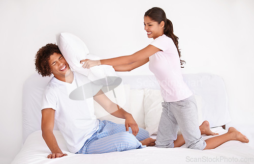 Image of Man, woman and pillow fight in morning on bed for holiday love connection, funny or vacation. Happy partnership, cushion and pajamas or laughing game in home for playing couple comedy, joy or smile