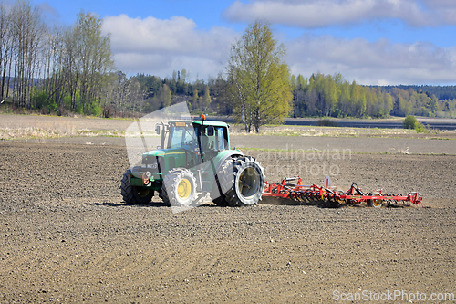 Image of John Deere Tractor and Tine Harrow in Field