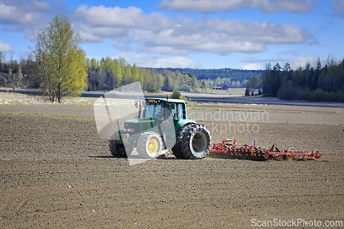 Image of John Deere Tractor and Vaderstad Tine Harrow in Field