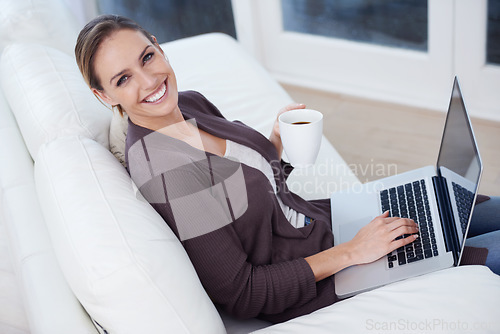 Image of Portrait, laptop and happy woman on a sofa with coffee while streaming movie, film or video at home. Pc, face or female person in a living room with tea, break or social media, subscription or show