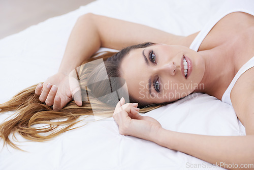 Image of Woman, calm and relaxing on bed in portrait, lazy and comfortable on morning at home. Female person, smiling and satisfaction while resting in bedroom, wake up and good mood on vacation or holiday