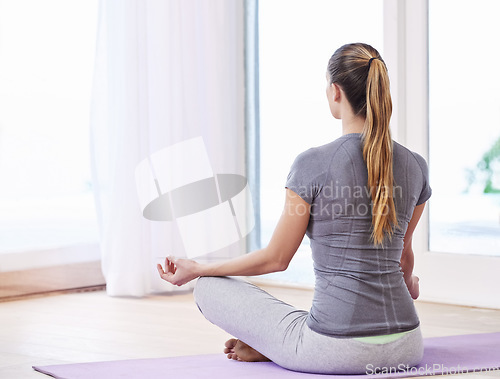 Image of Woman, back and meditation with lotus pose for mindfulness, mental health and physical wellbeing. Yoga, exercise and healing at home, holistic and aura balance with peace of mind for calm and zen