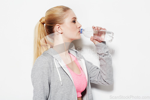 Image of Woman, drinking water and workout in studio profile, thinking and vision for fitness by white background. Girl, model and person with bottle, liquid and hydration for detox, wellness and nutrition