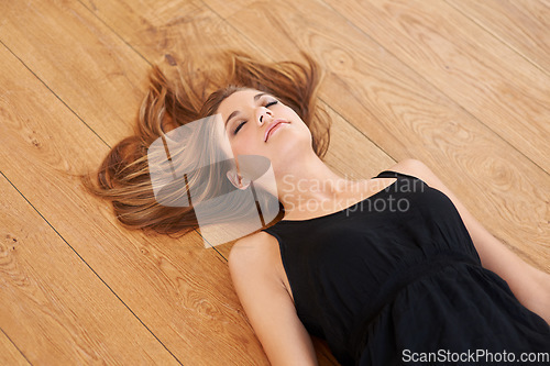 Image of Wood, floor and woman with beauty sleep in home or relax in Switzerland apartment. Tired, person and calm girl lying on ground in house and rest in lounge with healthy breathing, meditation or peace