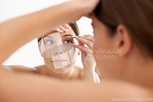 Image of Beauty, mirror reflection and woman face for eyebrow maintenance, hair removal or cosmetic routine. Bathroom, tweezers and studio person grooming with facial plucking tools on white background