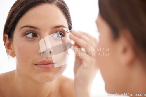 Image of Plucking, eyebrow and woman in mirror with beauty, tweezers and self care in bathroom. Makeup, routine and girl with hair removal, tools and facial grooming for skincare and cosmetics results