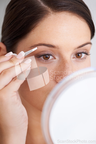Image of Plucking, eyebrow and woman with tweezers for beauty, self care and mirror in bathroom. Makeup, routine and girl with hair removal, tools and facial grooming or cleaning for skincare and cosmetics