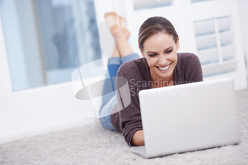 Image of Happy woman, remote work and laptop to relax on floor, update blog post and digital news on social media at home. Freelancer, computer and download subscription, online shopping and streaming movies