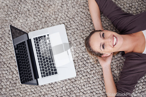 Image of Woman, laptop and above floor for portrait, smile and relax on break with remote work from home. Person, freelance worker and computer on carpet, rest and happy for blog writing job in apartment