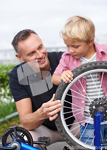 Image of Bicycle, wheel or repair with father and son outdoor in neighborhood for learning or child development. Family, street and fixing with man parent teaching young boy tyre maintenance for cycling