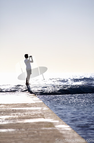 Image of Silhouette, waves and ocean, man and photography with phone on holiday and travel in Miami, mockup space and summer. Adventure, content creator or influencer with picture for blog and sea view