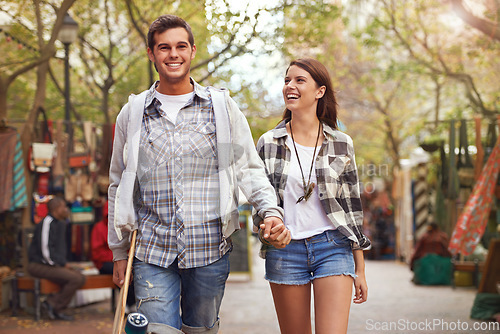 Image of Smile, walking and couple holding hands on city journey, morning trip or weekend tour of urban Spain for outdoor adventure. Love, skateboard and young people bonding together on relax commute